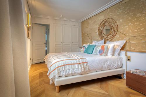 a bedroom with a bed with a mirror on the wall at La Chartreuse du Château La Garde in Martillac