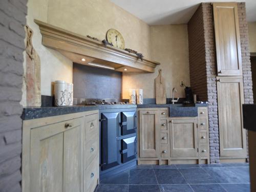 a large kitchen with white cabinets and blue counters at Group Stay with Private Pool and Sauna in Alphen