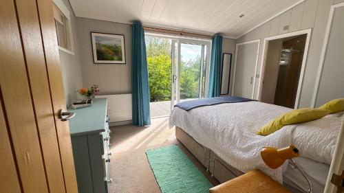 a bedroom with a bed and a large window at Wye Knot - Modern Country Retreat with Views in Mathon