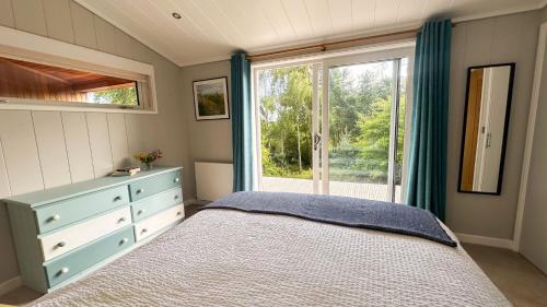 a bedroom with a bed and a large window at Wye Knot - Modern Country Retreat with Views in Mathon
