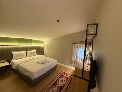 a bedroom with a bed and a tv on the wall at OTTO X Hotel in Kavaklıdere
