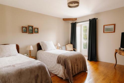 a bedroom with two beds and a window at Pavillon de l'octroi du Château de Tavannes in Aisey-sur-Seine