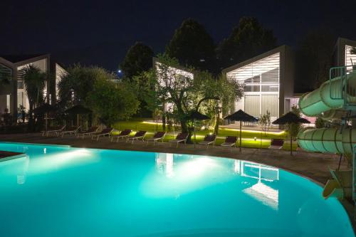 a swimming pool at night with a water slide at Garda Sporting Club Hotel in Riva del Garda