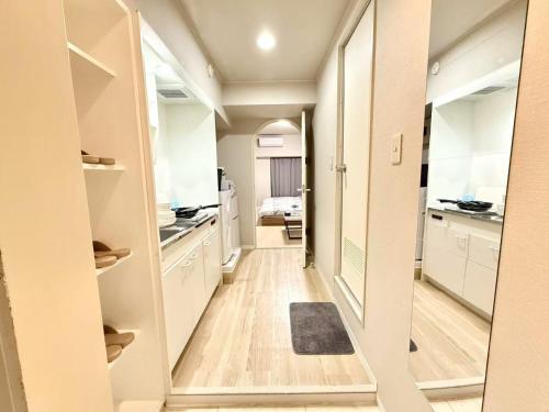a hallway of a kitchen with white cabinets at 池袋 Energy CA0 a9 in Tokyo