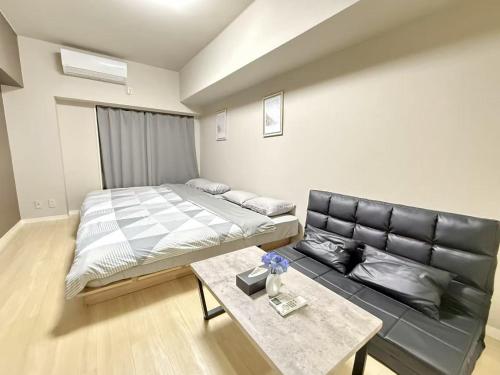 a bedroom with a bed and a couch and a table at 池袋 Energy CA0 a9 in Tokyo