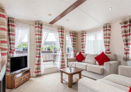 a living room with a couch and a tv at The Ness Hot tub Lodge in Fort Augustus