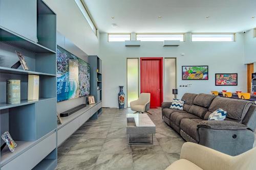a living room with a couch and a red door at NEW! Luxury Villa 3 BR - Miami inspired design - Villa Piel in Rawai Beach