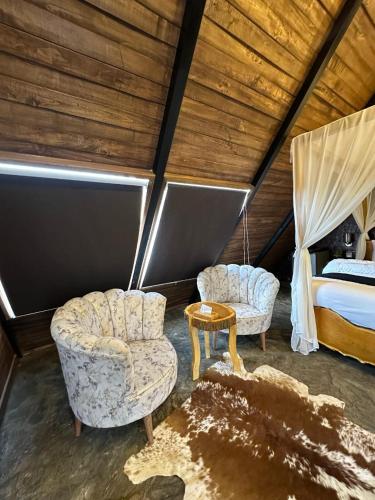 a bedroom with two chairs and a bed in a room at Gumaan Resort in Skardu