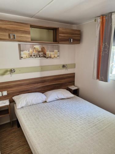 a bedroom with a bed and a mirror on the wall at Camping Onlycamp Les Chênes Verts in Cabrières-dʼAigues