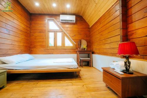 a bedroom with a bed in a wooden room at Ume Hotel & Retreat in Bóng Suối