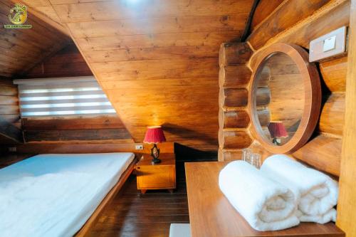 a bedroom in a cabin with a bed and a mirror at Ume Hotel & Retreat in Bóng Suối