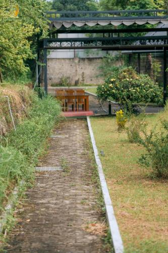 a brick path with a bench in a park at Ume Hotel & Retreat in Bóng Suối