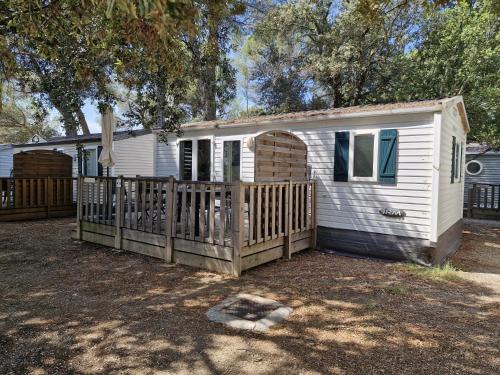 Cabrières-dʼAiguesにあるCamping Onlycamp Les Chênes Vertsの木塀のある小さな白い家