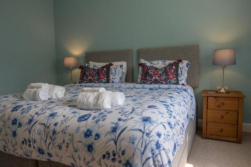 - un lit bleu et blanc avec des serviettes dans l'établissement Heritage Swiss Cottage, à Matlock Bank