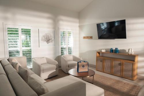 a living room with a couch and chairs and a tv at Islander Resort in Islamorada
