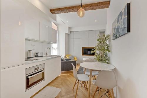 a kitchen and dining room with a table and chairs at Les Relais du Capitole - Appartements d'hôtes in Toulouse