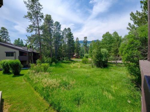 a yard with green grass and trees at RMR: Hawthorne 222 Condo in The AspensWilsonWY in Wilson