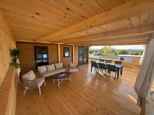 a wooden porch with a couch and tables on a deck at The Nest in Drage