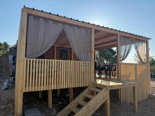 a wooden cabin with a canopy and a table at The Nest in Drage