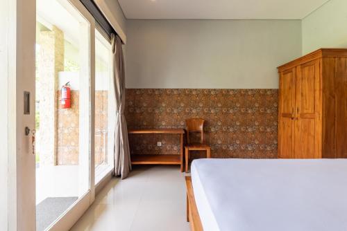 a bedroom with a bed and a large window at Urbanview Asung 2 Guesthouse near Canggu in Dalung