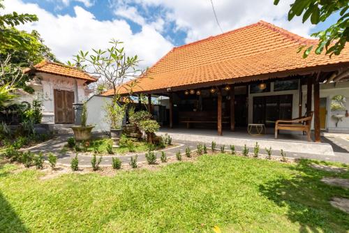 a house with a garden in front of it at Urbanview Asung 2 Guesthouse near Canggu in Dalung
