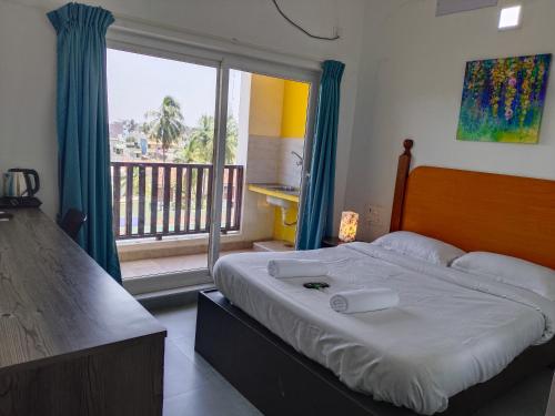 a bedroom with a bed and a large window at Auro Maison in Puducherry