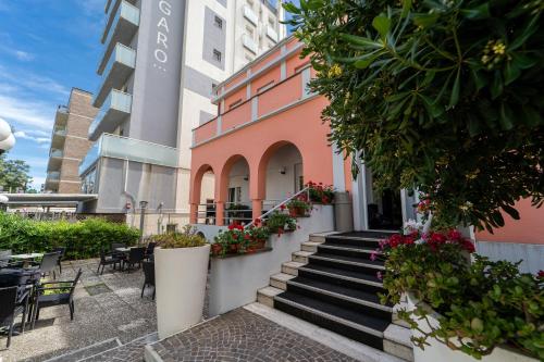 a building with stairs and flowers in a courtyard at Amadei Hotel Blumen in Pesaro