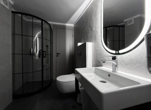 a bathroom with a sink and a toilet and a mirror at OTTO X Hotel in Kavaklıdere