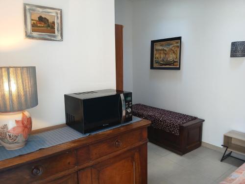 a living room with a television and a bed at Chambre avec SDB WC à 100 m du départ du GR20 in Calenzana