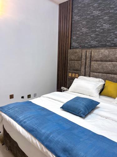 a large bed with a blue pillow on it at dreamland hotel in Abuja