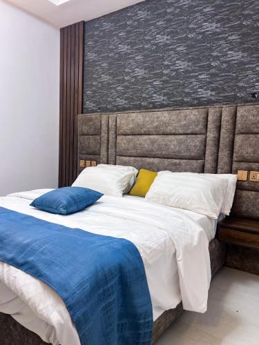 a bedroom with a large bed with blue and white pillows at dreamland hotel in Abuja