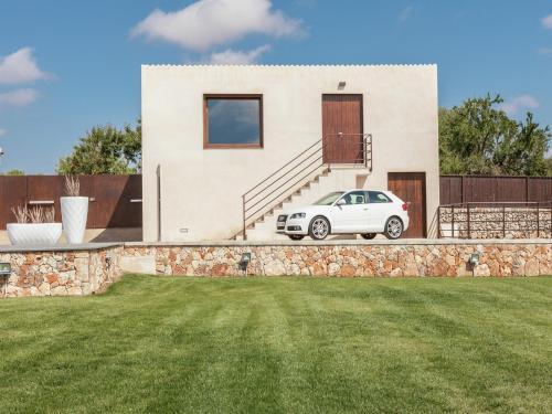 a white car parked in front of a house at Villa in Muro with Pool and Tramontana Views in Muro