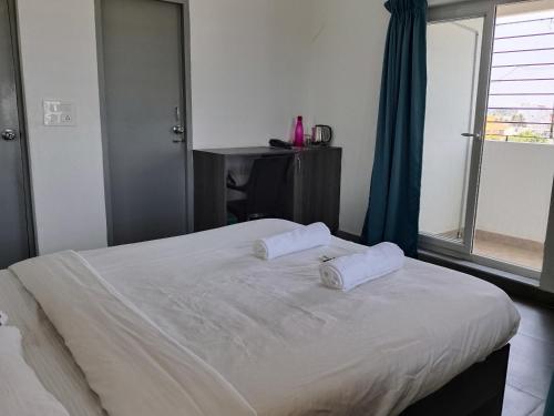 a bedroom with a bed with two white pillows on it at Auro Maison in Puducherry