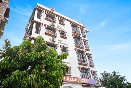 a tall white building with a sign on it at Hotel O Shraddha Residency 2 in Pānchuria