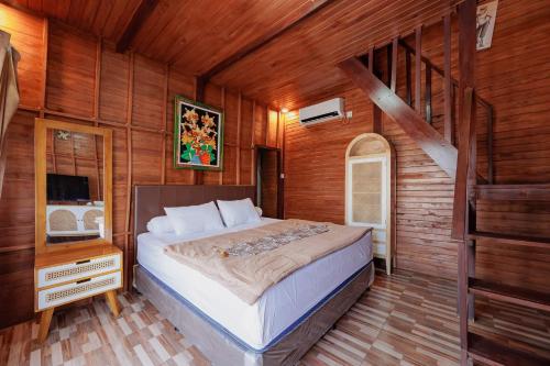 a bedroom with a bed in a wooden room at The Lavana De'Bale Marcapada in Saba