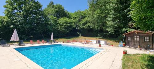a swimming pool with chairs and a house at Gîte Réole in Reignac
