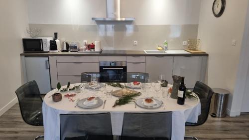 a table with plates and wine glasses on it in a kitchen at Gîte Réole in Reignac