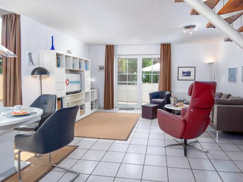 a living room with a red chair and a couch at Holiday Home Richtpfad by Interhome in Norden