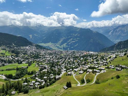 a town on a hill with mountains in the background at Apartment Arvine combles by Interhome in Verbier