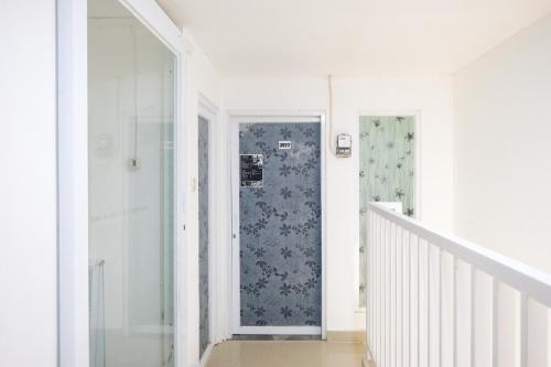 a white hallway with a door and a staircase at David Houses Nusa Dua Beach Bali RedPartner in Nusa Dua