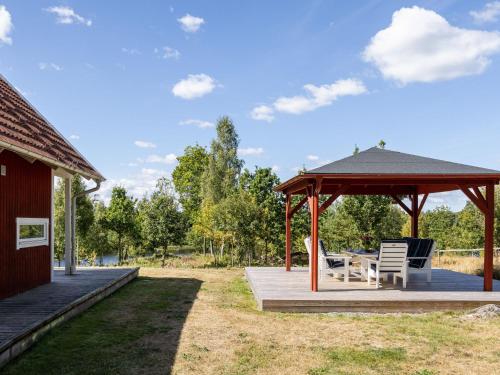 a pavilion with a table and chairs on a deck at Holiday Home Skogstorp by Interhome in Holmsjö