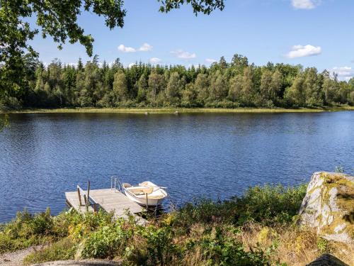 a boat on a dock on a lake at Holiday Home Skogstorp by Interhome in Holmsjö