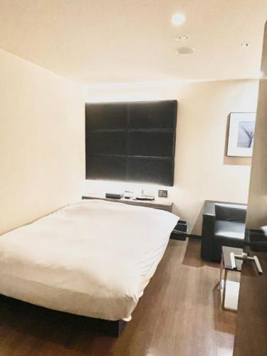 a bedroom with a bed and a blackboard on the wall at Hotel BIX チェックイン23時 変更不可 in Tokyo