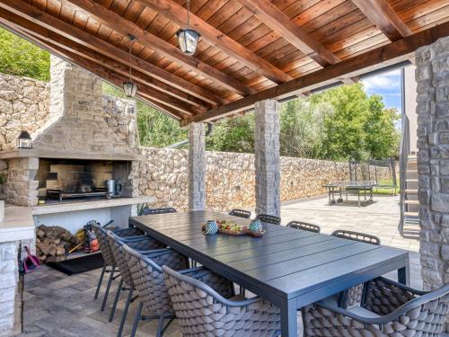 a patio with a table and chairs and a stone wall at Villa Le Maris by Interhome in Dobrinj
