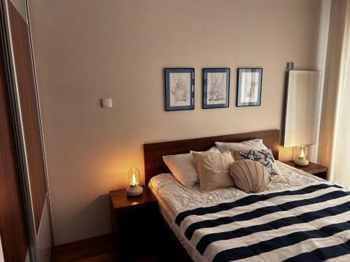 une chambre avec un lit avec trois tableaux au mur dans l'établissement Morska Ballada apartament 43m2 przy morzu, garaż, basen, sauny, à Jastrzębia Góra