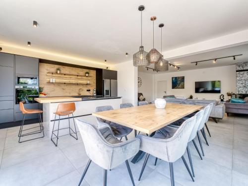 a kitchen and dining room with a wooden table and chairs at Villa Le Maris by Interhome in Dobrinj