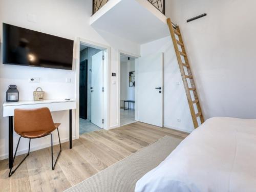 a bedroom with a bed and a desk with a television at Villa Le Maris by Interhome in Dobrinj
