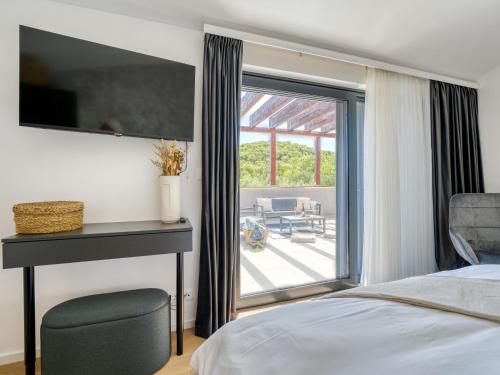 a bedroom with a bed and a sliding glass door at Villa Le Maris by Interhome in Dobrinj