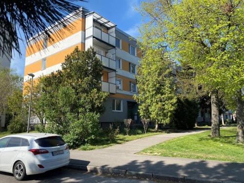a white car parked in front of a building at Mini Apartman - Parking free - 5 min center in Nitra