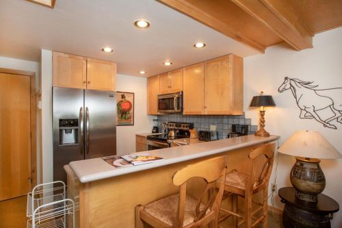 a kitchen with a counter and a refrigerator at RMR: La Choumine 8 Condo in Teton Village in Teton Village